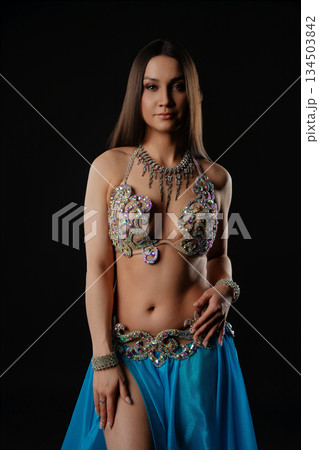 Woman performs dance with snake in dark setting during cultural event 134503842