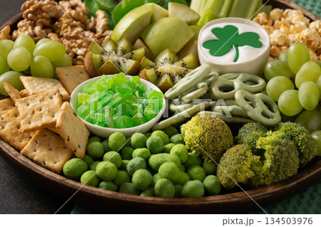 Green snack platter with fruits, vegetables and crunchy snacks arranged for St Patrick's Day celebration and festive party food concept. Green snack platter with fruits, vegetables and crunchy snacks arranged for St Patrick's Day celebration and festive party food concept. 134503976