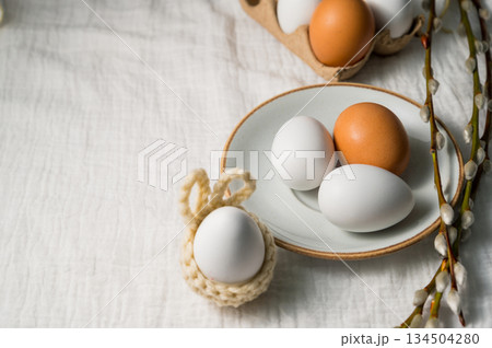Easter background. Willow branches, white eggs in a plate. Spring time. Minimalistic, copy space Easter background. Willow branches, white eggs in a plate. Spring time. Minimalistic, copy space 134504280
