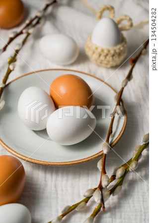 Easter background. Willow branches, white eggs in a plate. Spring time. Minimalistic top view 134504282