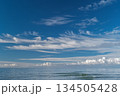 Panoramic view of a calm ocean and cumulus clouds on the horizon, background for advertising a resort vacation and a tourist cruise 134505428