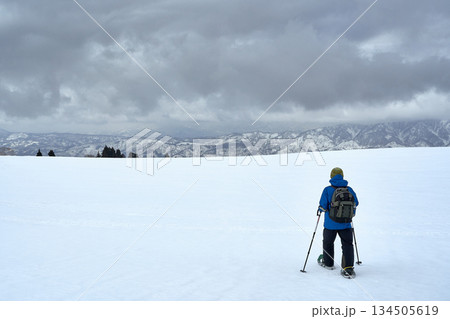 冬の雪原を歩くスノーシュー登山者 134505619