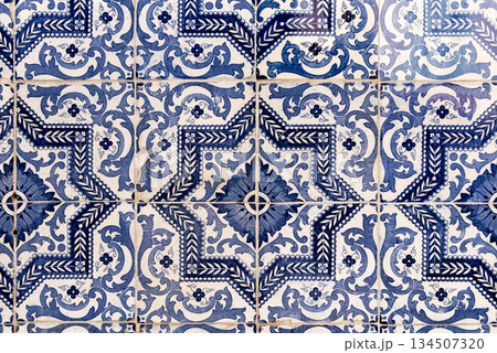 Ceramic tiles on old house wall with historical patterns in Portugal. 134507320