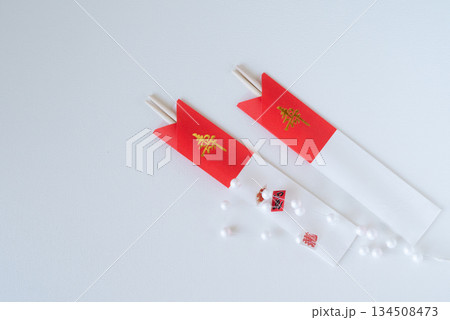 紅白の箸袋に入った祝い箸とお正月飾り 紅白の箸袋に入った祝い箸とお正月飾り 134508473