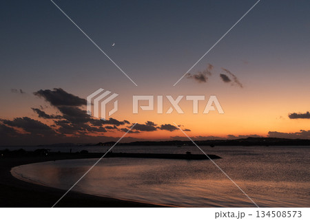 夕暮れの空の三日月とシルエットのビーチ 夕暮れの空の三日月とシルエットのビーチ 134508573