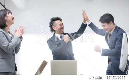 ハイタッチするビジネスマン　女性と上司の成功や成果などのビジネスシーン　 134511935