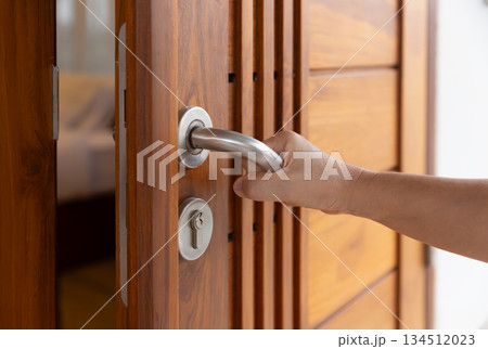 Stainless steel door handle on wooden door. 134512023