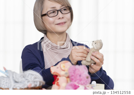 リビングでぬい活をするシニア女性 リビングでぬい活をするシニア女性 134512558