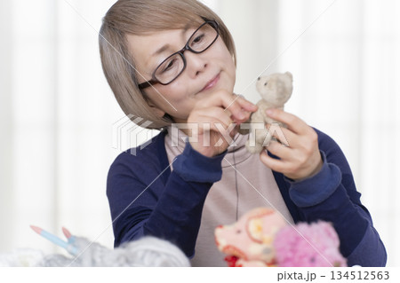 リビングでぬい活をするシニア女性 リビングでぬい活をするシニア女性 134512563