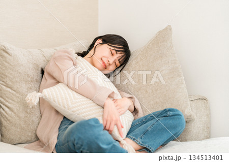 自宅のリビングのソファーで寝落ちする若いアジア人女性 自宅のリビングのソファーで寝落ちする若いアジア人女性 134513401