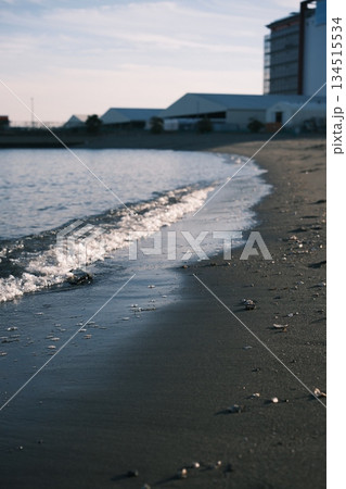 逆光に照らされた波と濡れた砂浜のクローズアップ 134515534