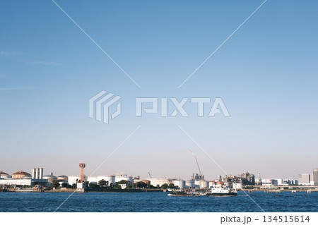 青空の下、水面越しに眺める京浜工業地帯の全景 134515614