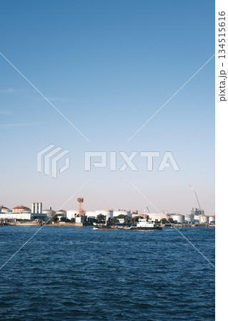 青空と海に広がる巨大な貯蔵タンク群と臨海工業地帯の景観 134515616