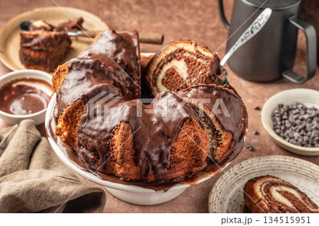 Chocolate marble bundt cake or zebra cake with chocolate glaze sliced on brown table background Chocolate marble bundt cake or zebra cake with chocolate glaze sliced on brown table background 134515951