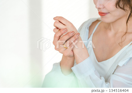 手の甲にハンドクリームを塗る日本人女性（スキンケア） 134516404