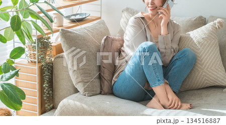 ソファーに座ってスマホで通話するお洒落な女性 134516887