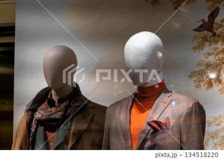 Stylish Mannequins in Fashion Store Window Display Wearing Cozy Autumn and Winter Attire 134518220