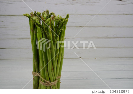 Bunch of fresh green asparagus stems on wooden background 134518975