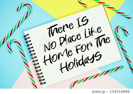 There Is No Place Like Home For The Holidays message of season holidays written on notepad with candy cane decoration on pastel background 134518998