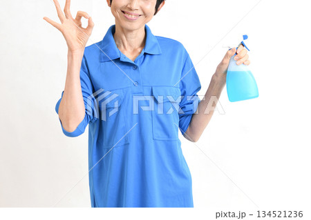 清掃用スプレーを持ちOKサインをする作業服のアジア人の中高年女性 清掃用スプレーを持ちOKサインをする作業服のアジア人の中高年女性 134521236
