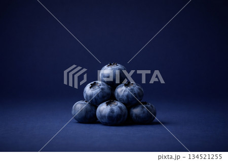 深いネイビーの背景にピラミッド状に積み上げたブルーベリー 134521255