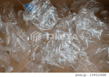 collection of empty plastic water bottles with white caps placed in cardboard box for recycling collection of empty plastic water bottles with white caps placed in cardboard box for recycling 134523096