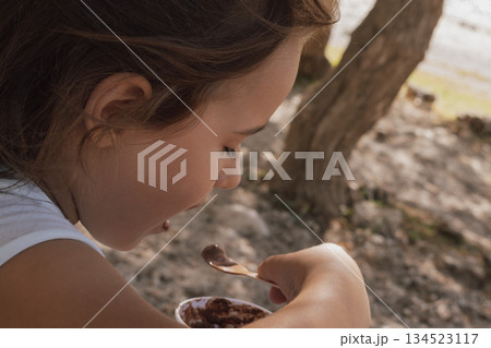 Simple summer joy: child enjoying a scoop of ice cream on a sunny day Simple summer joy: child enjoying a scoop of ice cream on a sunny day 134523117