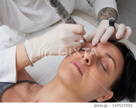 professional tattooist making permanent make up 134523502