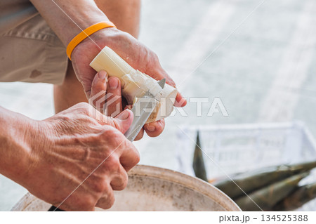 Farmer peeling bamboo shoot with knife in local market 134525388