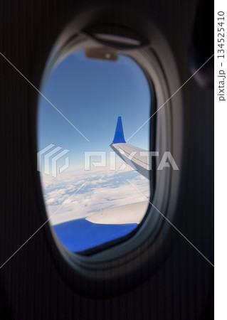 Airplane wing and clouds view from passenser window Airplane wing and clouds view from passenser window 134525410