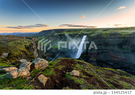 Scenic view of Haifoss waterfall and rugged canyon landscape during sunset in Icelandic Highlands Scenic view of Haifoss waterfall and rugged canyon landscape during sunset in Icelandic Highlands 134525417