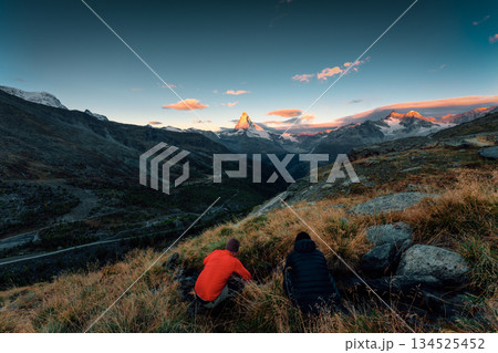 Sunrise over Matterhorn mountain with tourists taking pictures on wilderness during autumn at Zermatt, Switzerland 134525452