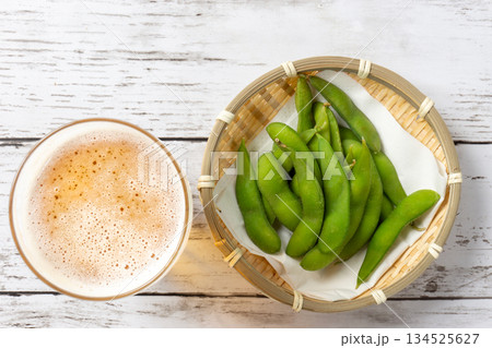 白いテーブルの上に乗ったビールと枝豆 134525627