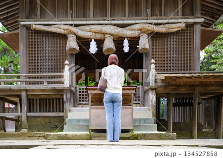 神社の拝殿で参拝する女性 134527858