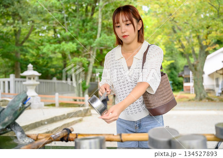 神社の手水舎で清める女性 134527893