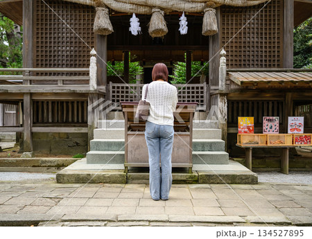 神社の拝殿前で参拝する女性 134527895