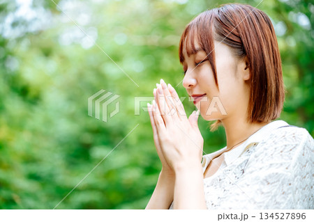 自然の中で合掌する女性の横顔 134527896