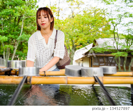 神社の手水舎で手を清める女性 神社の手水舎で手を清める女性 134527897