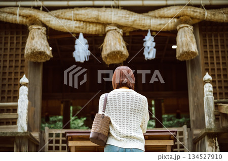 神社で参拝する女性の後ろ姿 134527910