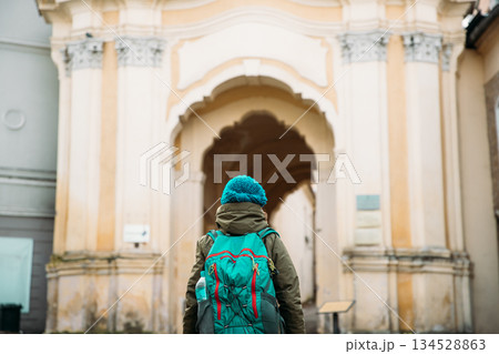 Vilnius, Lithuania. Young Beautiful Pretty Caucasian Girl Woman Tourist Smiling On Background Holy Trinity Church And Basilian Gate Vilnius, Lithuania. Young Beautiful Pretty Caucasian Girl Woman Tourist Smiling On Background Holy Trinity Church And Basilian Gate 134528863
