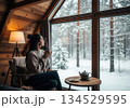 Cozy cabin window view with woman and tea 134529595