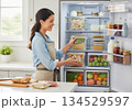 Woman organize meal prep pack in refrigerator 134529597