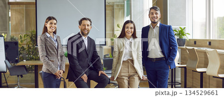 Team of four happy young successful business professionals at work meeting in office Team of four happy young successful business professionals at work meeting in office 134529661