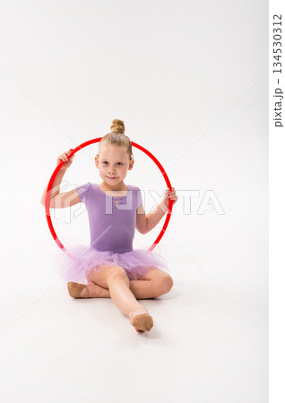 Little girl with cochlear implant sitting with red hoop. Symbol of inclusion, awareness, and artistic expression through hearing recovery and creativity. Little girl with cochlear implant sitting with red hoop. Symbol of inclusion, awareness, and artistic expression through hearing recovery and creativity. 134530312