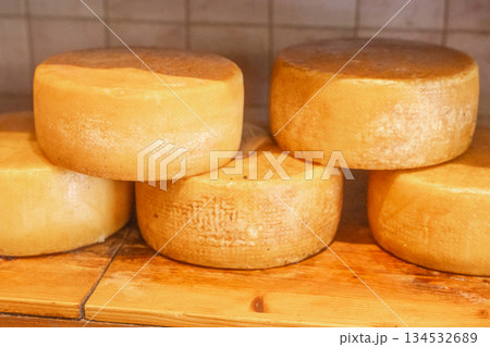 Close-up of cheese wheels displayed in shop. Natural food texture and gourmet concept Close-up of cheese wheels displayed in shop. Natural food texture and gourmet concept 134532689