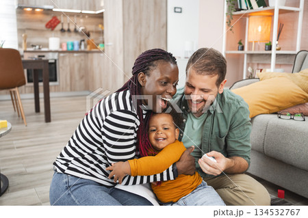 Multiracial family enjoying time together in their cozy home Multiracial family enjoying time together in their cozy home 134532767