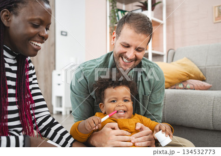 Multiracial family enjoying playtime in a cozy living room 134532773