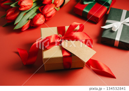 Mothers' day. Gift boxes and fresh red spring tulips. Easter holiday. Red background Mothers' day. Gift boxes and fresh red spring tulips. Easter holiday. Red background 134532841