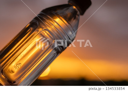 夕空と水の入ったペットボトル｜斜め 134533854