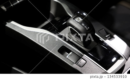 Car gear. Close up of modern car automatic gear selector or electronic shifter. Premium interior design EV car gears driving control. auto transmission modes. Automotive technology in motion driving. Car gear. Close up of modern car automatic gear selector or electronic shifter. Premium interior design EV car gears driving control. auto transmission modes. Automotive technology in motion driving. 134533910